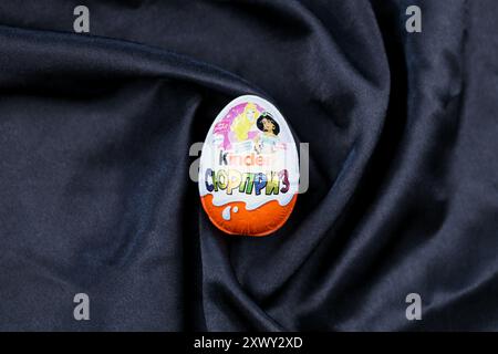 KYIV, UKRAINE - AUGUST 17, 2024 Kinder egg chocolate product with foil wrapping from famous manufacturer close up Stock Photo