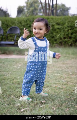 cute toddler trying to walk at park green grass from different angle Stock Photo