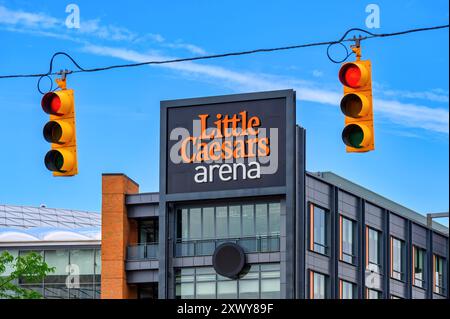 Detroit, USA - August 1, 2024: Exterior architecture and sign at Little Caesars Arena. The building is framed in two stoplights. Stock Photo