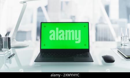 Laptop Computer with Mock Up Green Screen with Chromakey Display with Motion Trackers Standing on a Modern Office Desk. Table Space with a Mouse, Notebook, and Black Pens. Stock Photo