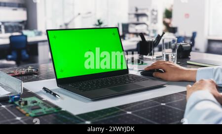 Anonymous Engineer Working in the Lab on a Laptop Computer with Mock Up Green Screen Chromakey Display with Motion Tracker Placeholders. Photo Template for Industrial Content Creation and Presentation Stock Photo
