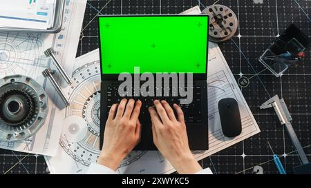 Anonymous Engineer Typing on a Laptop Computer with Mock Up Green Screen Chromakey Display with Motion Tracker Placeholders. Scientist Corresponding with Work Partners by Email. Top Down View Stock Photo