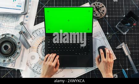 Anonymous Engineer Typing on Laptop Computer with Mock Up Green Screen Chromakey Display with Motion Tracker Placeholders. Scientist Corresponding with Work Partners by Email. Top Down View Stock Photo