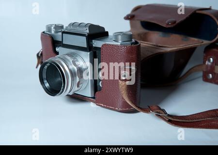 old analog camera in a leather case - on white background Stock Photo