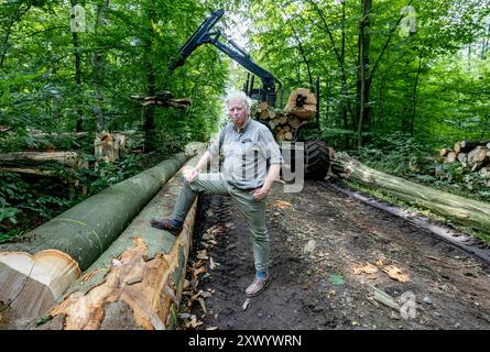 Pronstorf, Germany. 20th Aug, 2024. Hans-Caspar Graf zu Rantzau, Chairman of the Schleswig-Holstein Forest Owners' Association, stands in one of his forests in front of a so-called "forwarder", a vehicle that removes the timber from the stand during harvesting, loads it up and transports it to a passable forest road. Credit: Axel Heimken/dpa/Ģ����ý Live News Stock Photo
