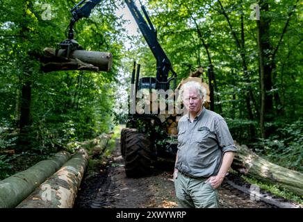 Pronstorf, Germany. 20th Aug, 2024. Hans-Caspar Graf zu Rantzau, Chairman of the Schleswig-Holstein Forest Owners' Association, stands in one of his forests in front of a so-called "forwarder", a vehicle that removes the timber from the stand during harvesting, loads it up and transports it to a passable forest road. Credit: Axel Heimken/dpa/Ģ����ý Live News Stock Photo