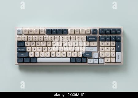 Modern mechanical keyboard isolated on blue background. Minimal style and design keyboard. Custom build keyboard. Colorful key cap. View from above. Stock Photo
