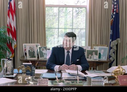 President Ronald Reagan at his desk in the White House Oval Office ...