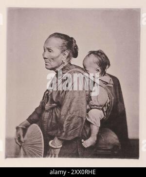 Vintage photo of an old Canton boat-woman and child. Illustrations of China, 1875 Many thousands of the population of Canton pass their lives in their boats; - in them they are born; and from them they are carried to their graves.; The old woman in the photograph is the grandmother living with her son's family in the boat; she still works cheerfully at the oar to help the domestic earnings; and nurses; all the while; one of the grandchildren. The babe is carried in a cloth slung over the shoulders; after the manner of the Chinese race. Stock Photo