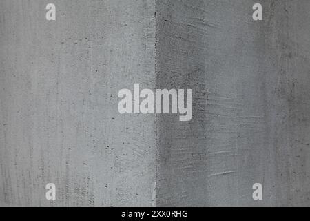 Grey wall texture, background. Concrete plaster surface. The corner of a wall or building. Smooth and flat cement plaster on the corner of building Stock Photo