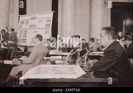 Mafioso Joseph Valachi of the Genovese crime family, testifying about organized crime and the Mafia at a hearing of the Permanent Subcommittee on Investigations of the Senate Committee on Homeland Security and Governmental Affairs (McClellan Committee), as man points to chart of Mafia organizations. USA, 1 October 1963 By T. J. O'Halloran Stock Photo