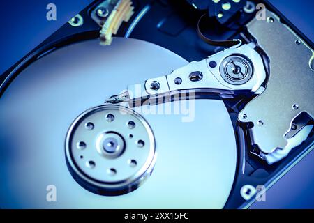 Close-up of a portable hard disk's read/write arm and platter, showcasing internal mechanics, data storage technology, and digital precision. Stock Photo