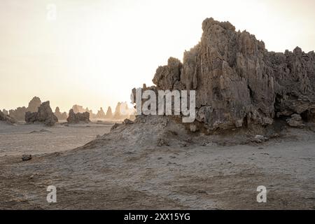 Moon landscape of limestone chimneys geological rock formations in a sunset rays at the bottom of dried salt lake Abbe, Djibouti Stock Photo