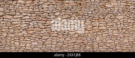 Wall made of many small brown natural stones - house wall in Fuerteventura Stock Photo