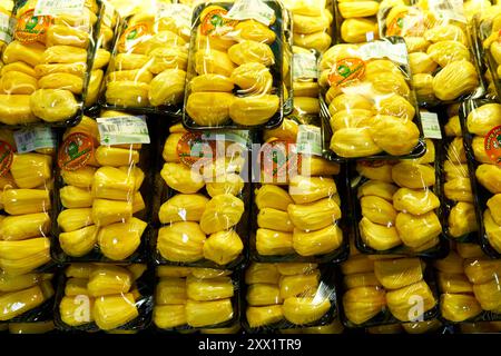 An assortment of fresh, ripe jackfruit sliced and packaged in individual portions is sold in an Asian supermarket. Kuala Lumpur, Malaysia - 05.30.2020 Stock Photo