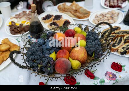 Various fruits and vegetables in a basket. plums, grapes, tomatoes and cucumber Stock Photo