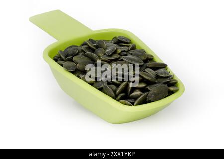 Measuring spoon full of Pumpkin seeds isolated on a white background Stock Photo