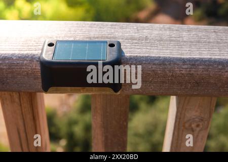 Small solar powered led light with motion sensor on wooden terrace Stock Photo