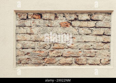 Old brick wall frame in beige painted plastered wall background. Vintage and modern wall background Stock Photo