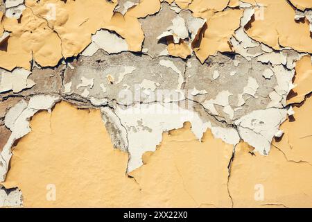 Abstract grunge wall background. Old plastered wall with many cracks. Grungy texture with deep pattern on yellow painted wall Stock Photo