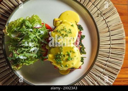 Overhead view of a plate of Eggs florentine on a wooden table Stock Photo