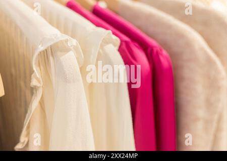 several shirts of different colors to wear in autumn hanging on hangers in a clothing store Stock Photo