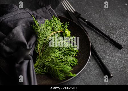 Close-up of a Christmas place setting with fresh thujia branches Stock Photo