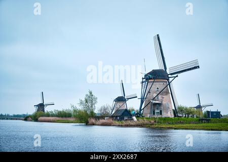 Kinderdijk, Rotterdam, Netherlands - April 11, 2024: Historic windmills and a river flowing by in Kinderdijk. 19 windmills was built around 1740 Stock Photo