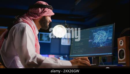 Middle Eastern admin programming AI used for machine learning inference training. Freelancer working from home running code on computer terminal, updating artificial intelligence neural networks Stock Photo