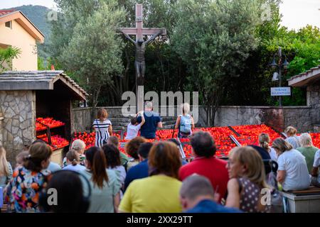 Pilgrims praying and lighting candles at the Cross near the Saint James Church in Medjugorje. Stock Photo
