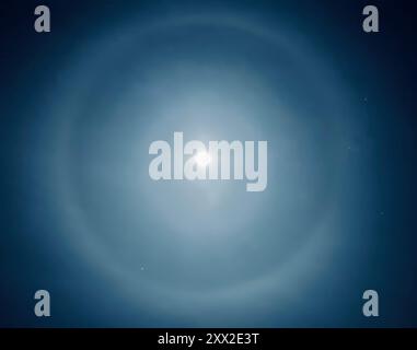 Two halos around the moon at night Stock Photo