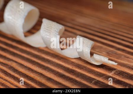 Pine wood shaving in cone shape on a brown wood board. Stock Photo