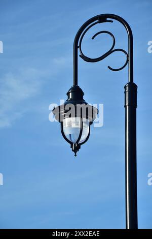 Black architectural pole street light with blue sky Stock Photo