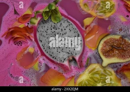 Array of exotic fruits and flowers in a pink bath. Stock Photo