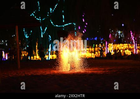 This photograph captures a dynamic and visually stunning moment of a fire performer in action. The vibrant colors of the flames. Stock Photo