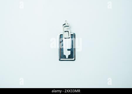A silver colored keychain with a small silver key for mosquito coils on it Stock Photo