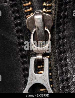 Not branded unidentified vintage metal zipper on black leather boots close up detail Stock Photo
