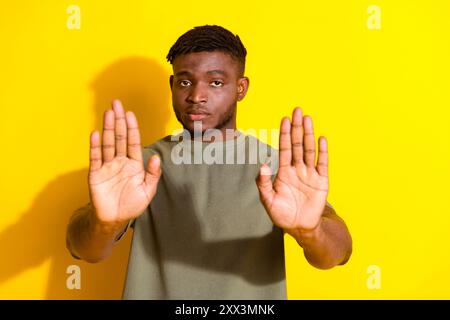 Photo of handsome nice man wear khaki stylish clothes stop sign isolated on yellow color background Stock Photo