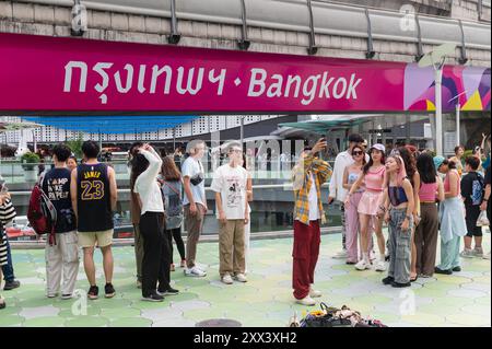 Group of tourists selfie at famous location a wording 'Bangkok' on skytrain track Stock Photo