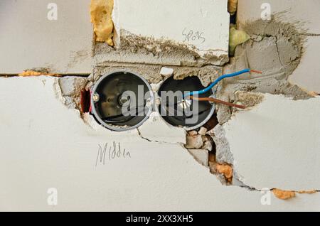 Two power sockets with electricity wires in an irregularly constructed wall during a renovation Stock Photo
