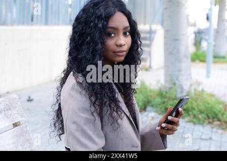 Young happy African American woman browsing the Internet with smart mobile application  Stock Photo