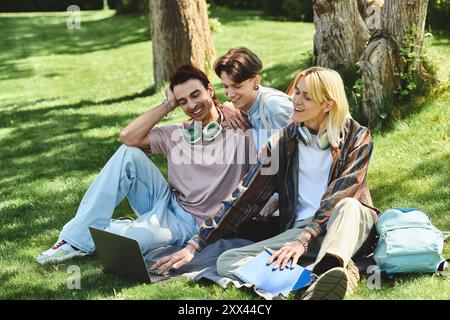 Three young queer friends laugh together in a park on a sunny day. Stock Photo