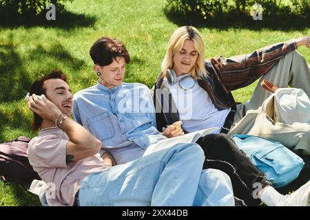 Three LGBTQIA friends relax on a sunny day in the park, laughing and chatting. Stock Photo