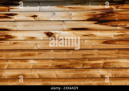 Top view of a small, unpainted, burnt brown wooden wall texture background, featuring a charred board Stock Photo
