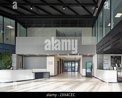 Entrance foyer with reception desk and cafe. Building 1180, Reading, United Kingdom. Architect: Spratley +  Partners, 2022. Stock Photo