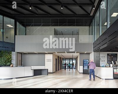 Entrance foyer with reception desk and cafe. Building 1180, Reading, United Kingdom. Architect: Spratley +  Partners, 2022. Stock Photo