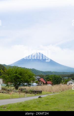Traditional thatched-roof homes with Mt. Fuji in the background on a clear day – Yamanashi Prefecture, Japan Stock Photo
