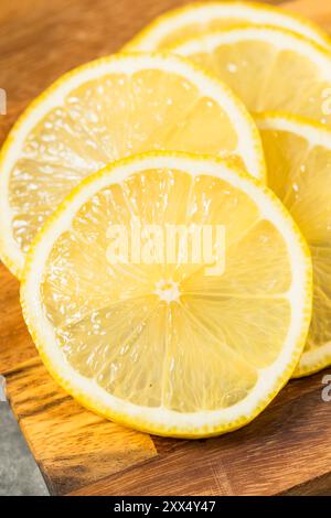 Organic Raw Yellow Sliced Lemons on a Cutting Board Stock Photo