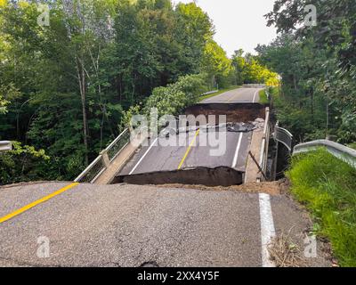 Road and bridge destroyed by the heavy rain and flood. Big holes before and after the bridge. Stock Photo