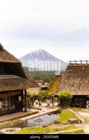 Traditional thatched-roof homes with Mt. Fuji in the background on a clear day – Yamanashi Prefecture, Japan Stock Photo